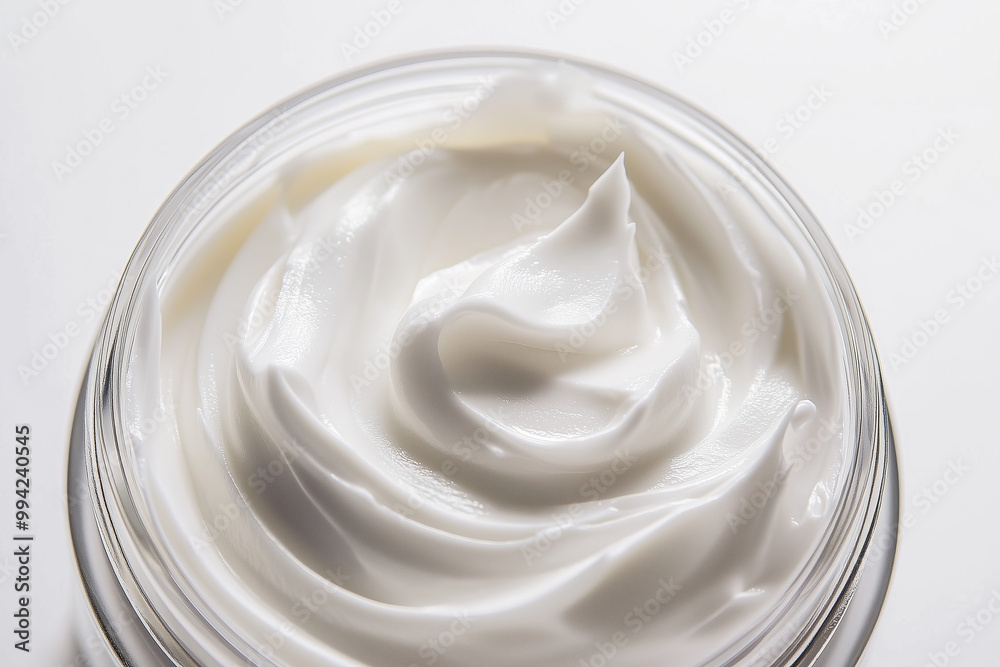 Open glass jar of white skincare cream product against white background. Open glass jar of white skincare cream product against white background.