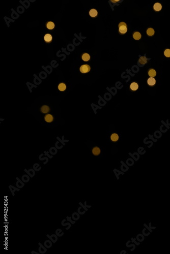 Golden blurred bokeh lights on black background. Glitter sparkle stars for celebrate. Overlay for your design