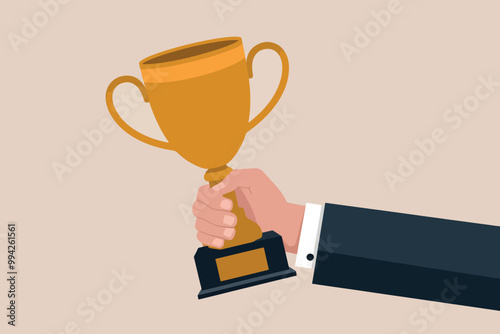 Hand of a businessman holding trophy, business and achievement concept.