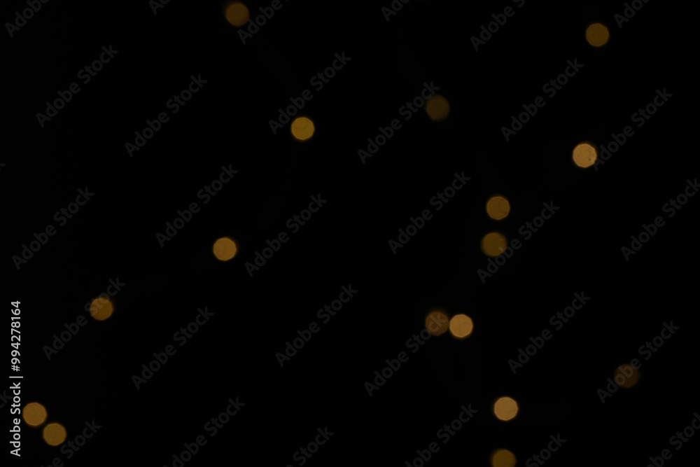 Golden blurred bokeh lights on black background. Glitter sparkle stars for celebrate. Overlay for your design Golden blurred bokeh lights on black background. Glitter sparkle stars for celebrate. Overlay for your design