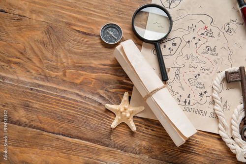 Obraz na plátně Treasure map with magnifier, scroll and compass on brown wooden background