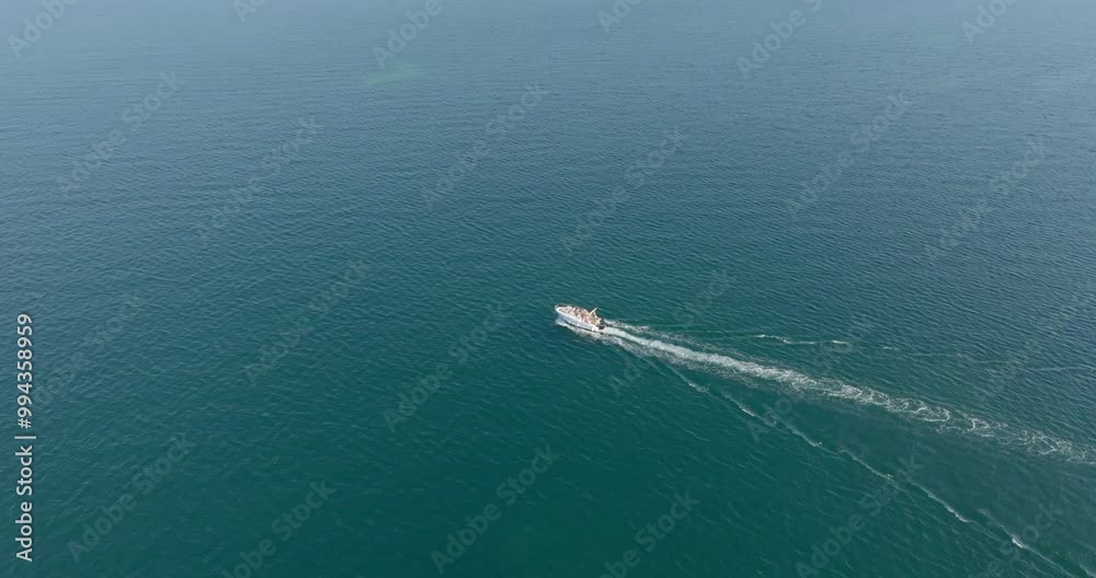 Aerial view of a small boat sailing in the blue Mediterranean Sea. Motorboat vacation concept. Aerial view of a small boat sailing in the blue Mediterranean Sea. Motorboat vacation concept.