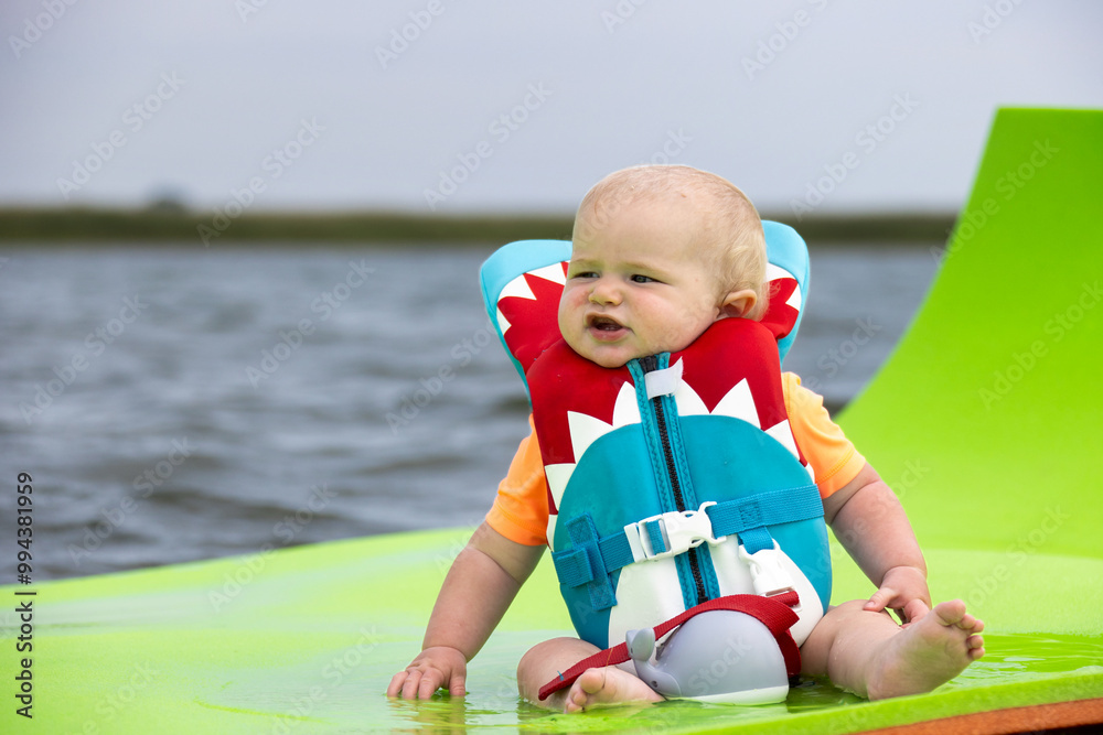 Little boy wearing a life jacket while floating on a raft. Little boy wearing a life jacket while floating on a raft.
