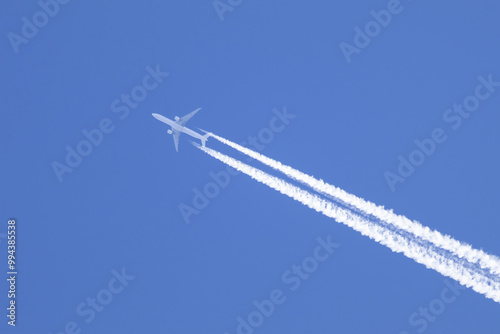 Telephoto close-up of jet plane aircraft with contrails cruising on the scottish sky
