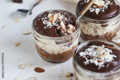 Photos Three jars of homemade chocolate overnight oatmeal with shredded coconut and sliced almonds
