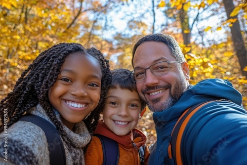 Happy family is enjoying their time together, taking a selfie while on an autumn hike in the woods