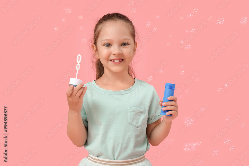 Cute little girl with soap bubbles wand on pink background Cute little girl with soap bubbles wand on pink background