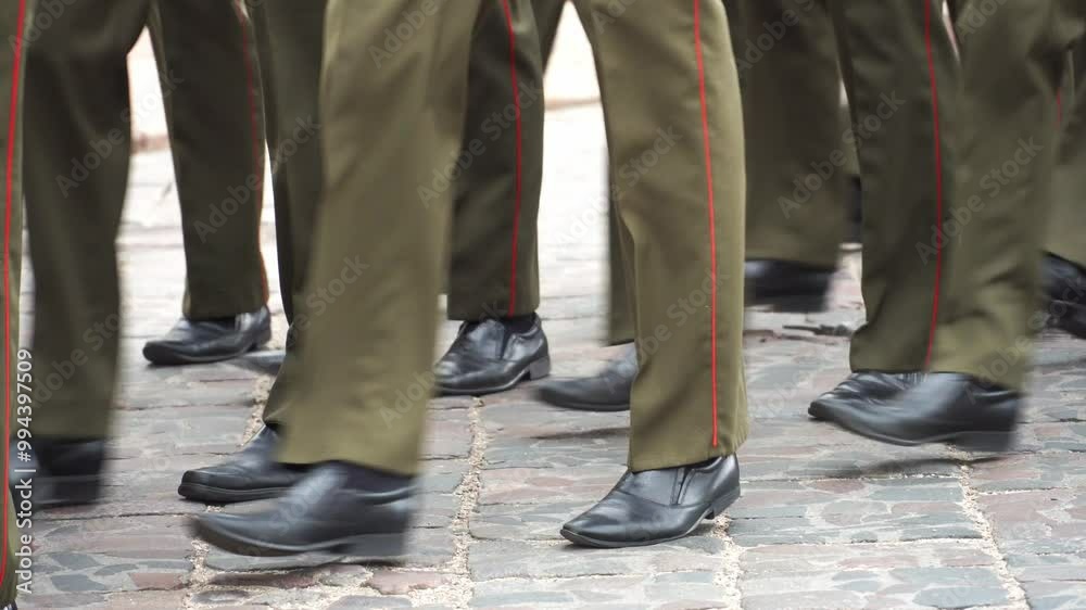 A military formation marches on parade. The soldiers are marching in formation. Military boots and uniforms of soldiers in close-up.