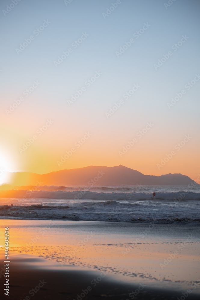 surfer watching the sea preparing the next wave at sunset surfer watching the sea preparing the next wave at sunset