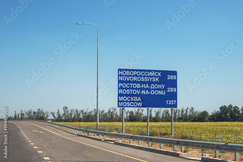 Road with road information sign. On the blue plate are the inscriptions of the cities Novorossiysk, Rostov-on-Don, Moscow with the distance to them