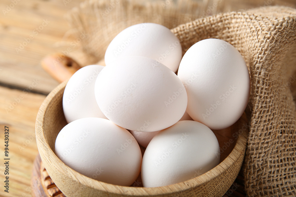 Bowl with raw chicken eggs on wooden background, closeup Bowl with raw chicken eggs on wooden background, closeup