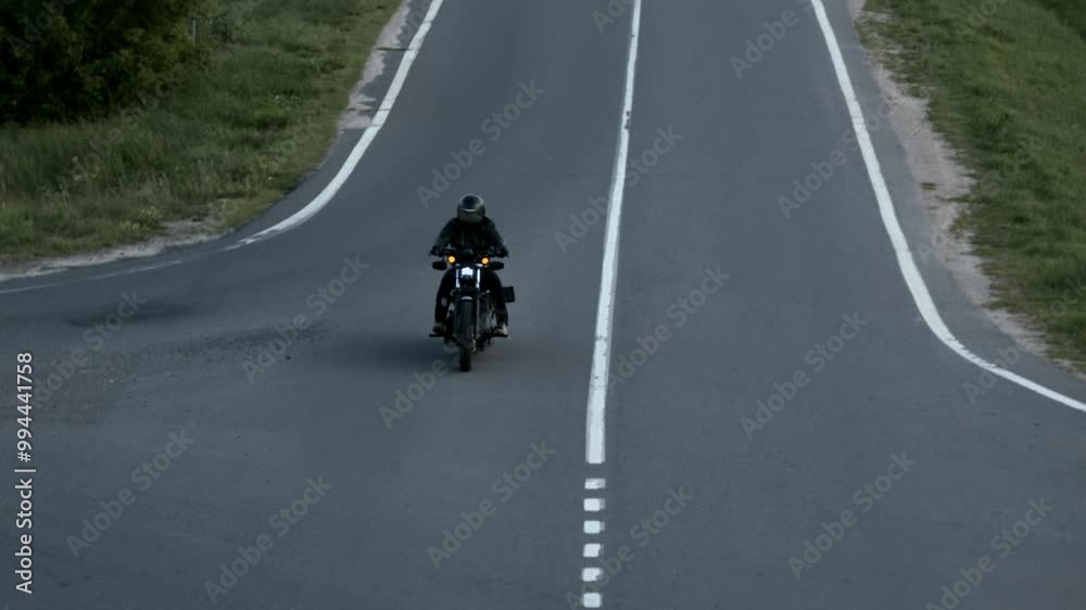 Man in full gear on motorcycle rushes along country highway and passes road intersection. Man in full gear on motorcycle rushes along country highway and passes road intersection.