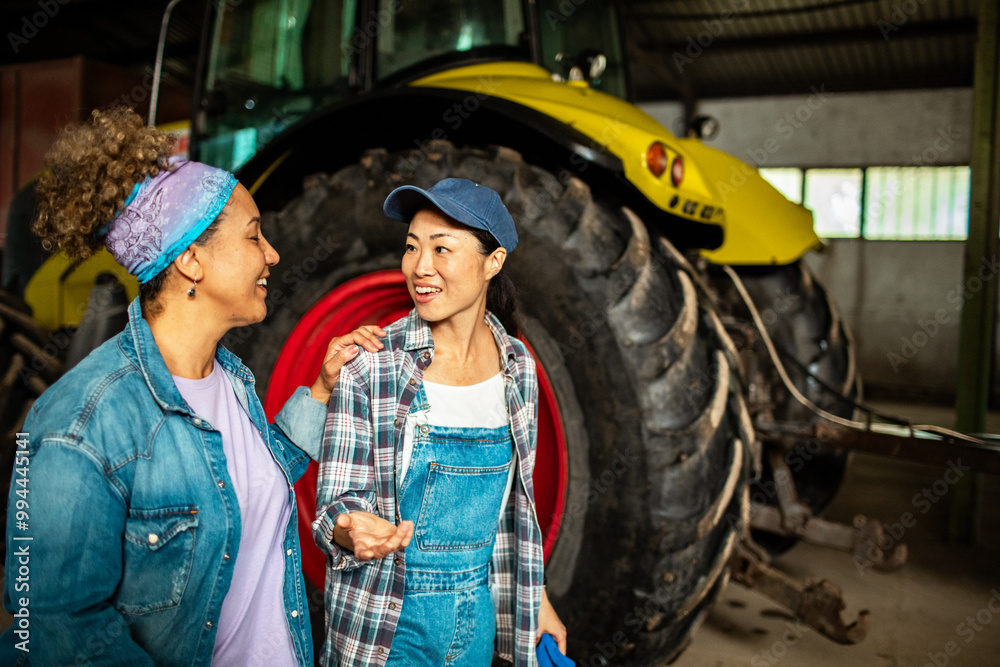 Two female farmers talking in warehouse next to truck Two female farmers talking in warehouse next to truck