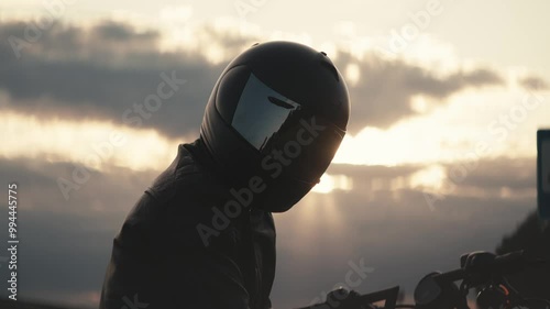 Portrait of biker in black helmet with tinted glass against cloudy sky. Sporting passion for motorcycles develops into whole way of life and gives real adrenaline and speed