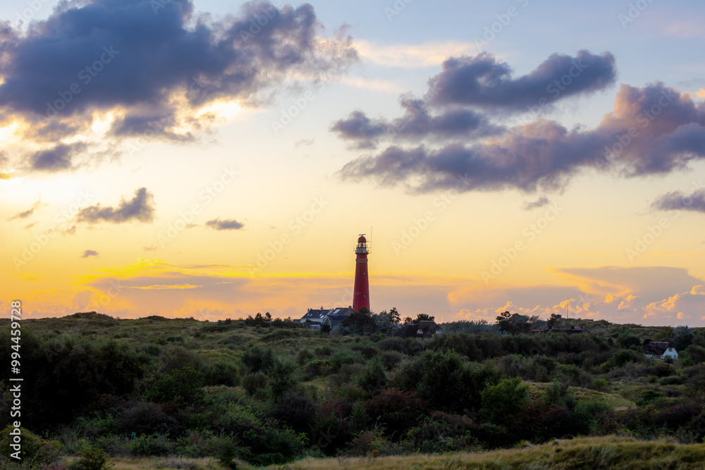 The red lighthouse north tower (Noordertoren) on the dune, Schiermonnikoog is a municipality and national park in the Northern Netherlands, One of the West Frisian Islands on the edge of the North Sea The red lighthouse north tower (Noordertoren) on the dune, Schiermonnikoog is a municipality and national park in the Northern Netherlands, One of the West Frisian Islands on the edge of the North Sea