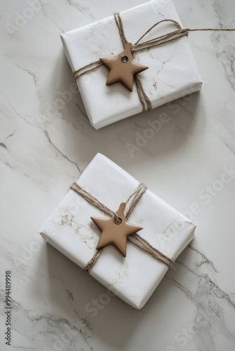 Elegant wrapped gifts with star ornaments on a marble surface