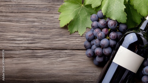 Grapes and wine bottle resting on a rustic wooden surface surrounded by green...