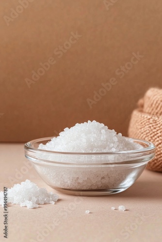Freshly harvested sea salt in a glass bowl with rustic background and scatter...