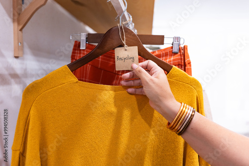 Hand selecting a recycled sweater in a clothes shop photo