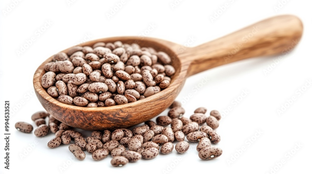 Many brown pinto beans with a spoon on white Many brown pinto beans with a spoon on white
