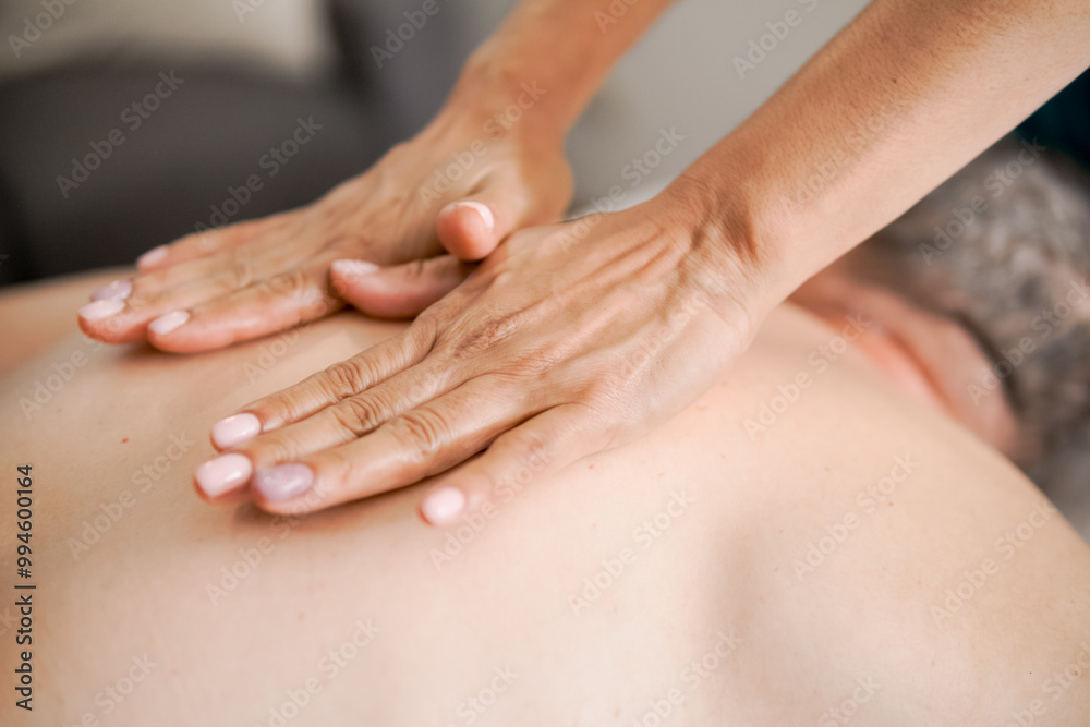 Therapist giving a back massage to a male client Therapist giving a back massage to a male client