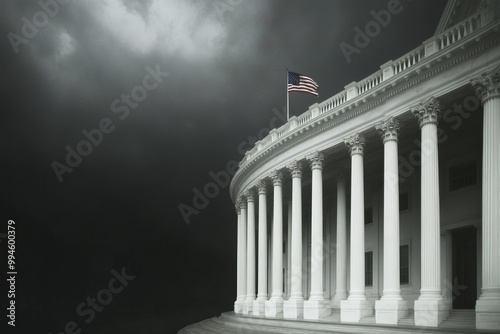 A large building with a flag on top of it. The building is white and the flag is red and white. The sky is dark and cloudy