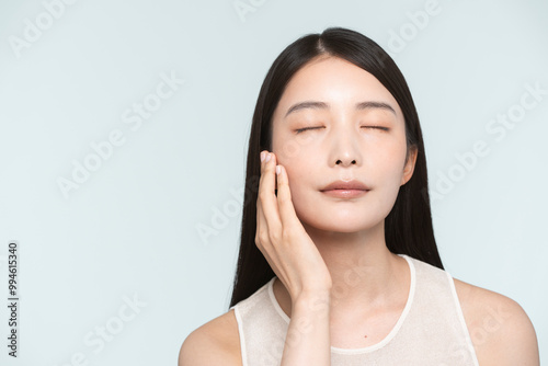 Skin care. Woman with beauty face touching healthy facial skin portrait. Asian woman. 