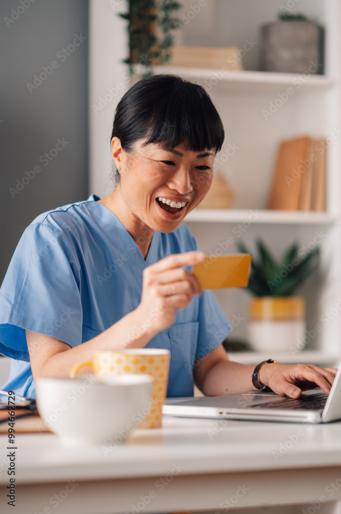 Asian female nurse online shopping on her laptop while working online from home Asian female nurse online shopping on her laptop while working online from home