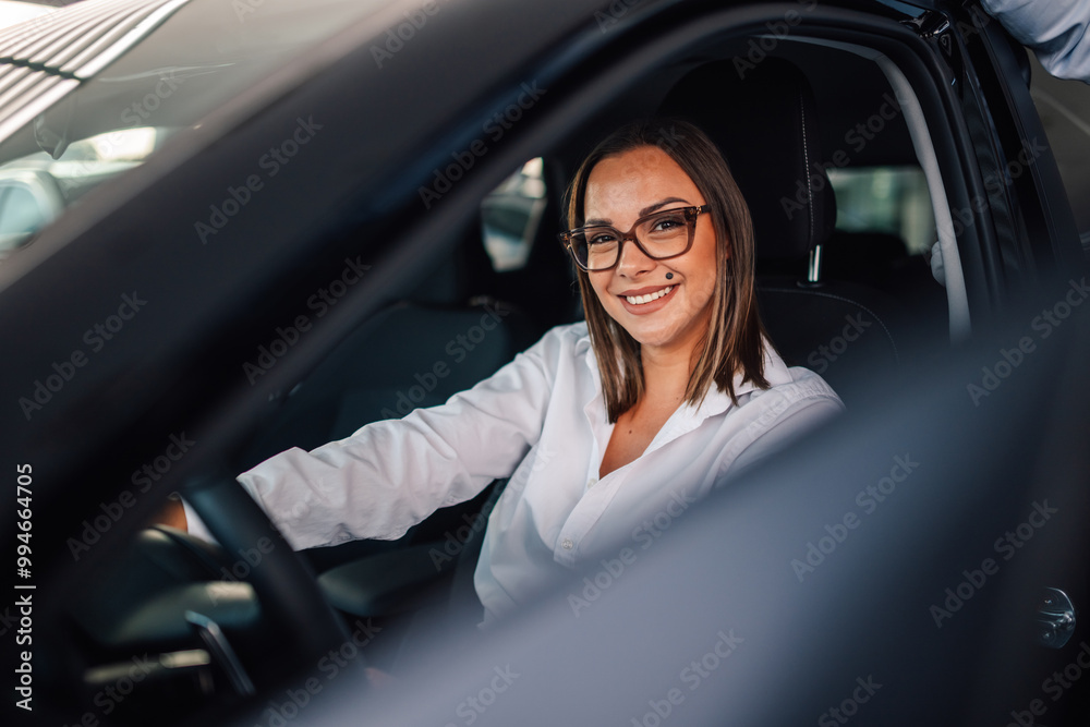 Smiling customer inquires about car's features in detail with help. Smiling customer inquires about car's features in detail with help.
