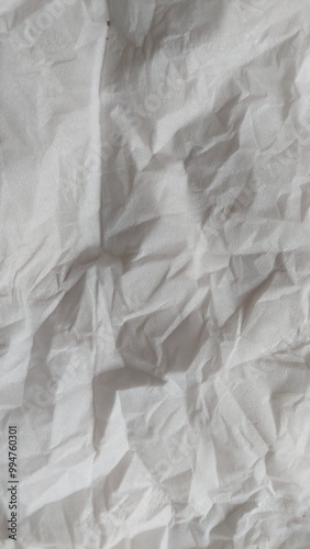 Close-up of white crumpled tissue paper. Soft, textured, and abstract background for your design projects. Perfect for creating a minimalist or grunge aesthetic.