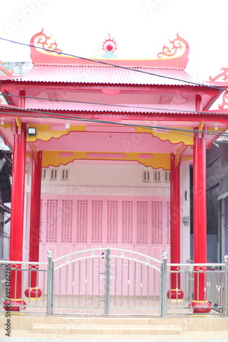 The building is painted a bright pink and has a traditional Chinese-style roof. photo