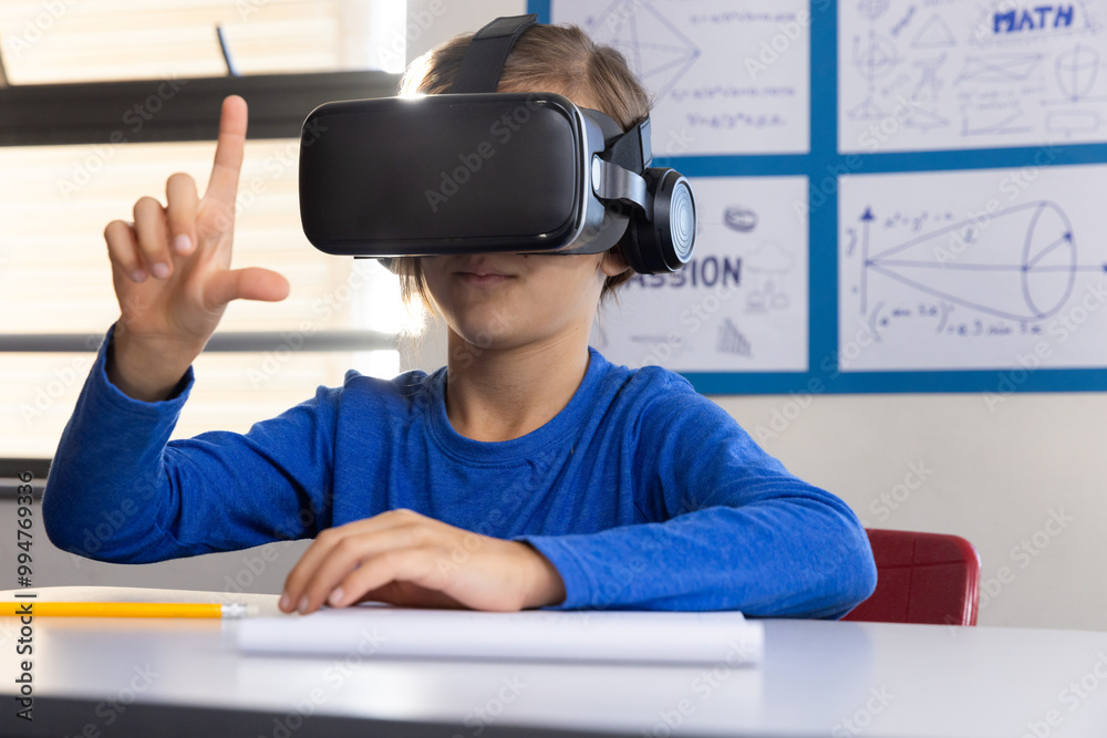 Using VR headset, boy in school exploring virtual reality in classroom ...