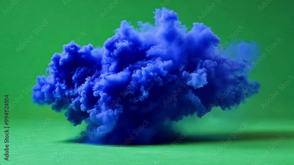 Mesmerizing blue smoke cloud emerges against a vibrant green screen ...