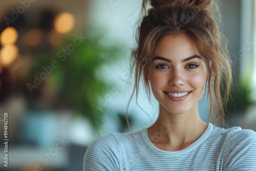 Empowered Young IT Woman in Striped Tee: Thriving in Casual Style with Laptop on Light Blue Backgr