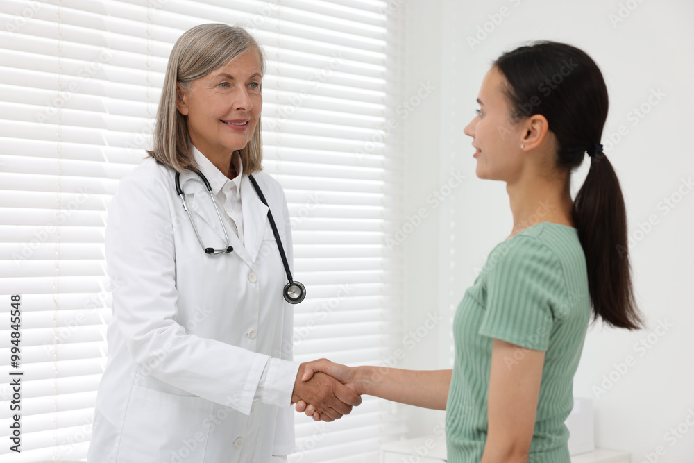 Senior doctor shaking hands with patient in hospital Senior doctor shaking hands with patient in hospital