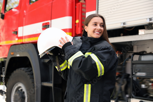 Portrait of firefighter in uniform with helmet near fire truck