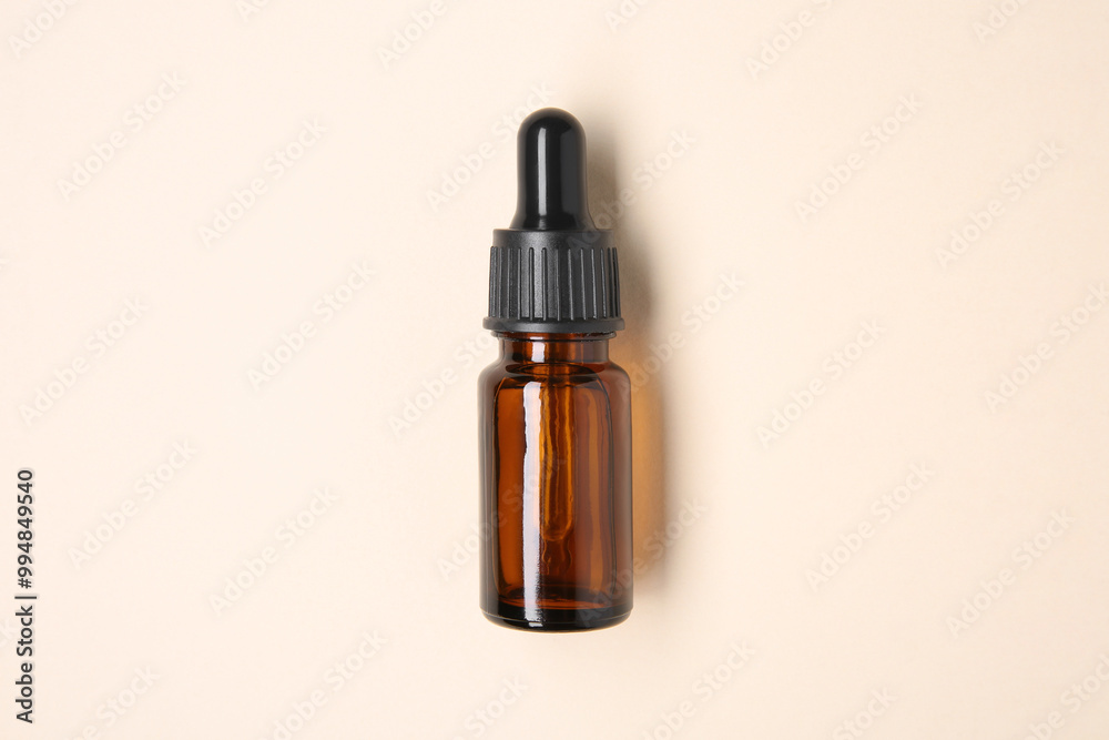 Essential oils in bottle on beige background, top view Essential oils in bottle on beige background, top view