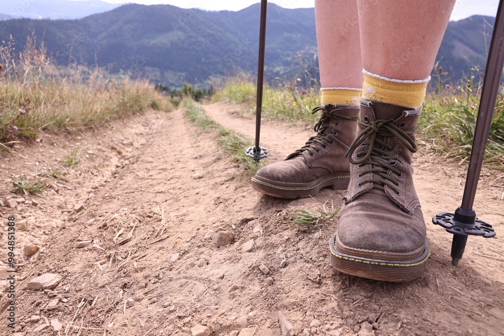 Young hiker with trekking poles in mountains, closeup. Space for text Young hiker with trekking poles in mountains, closeup. Space for text
