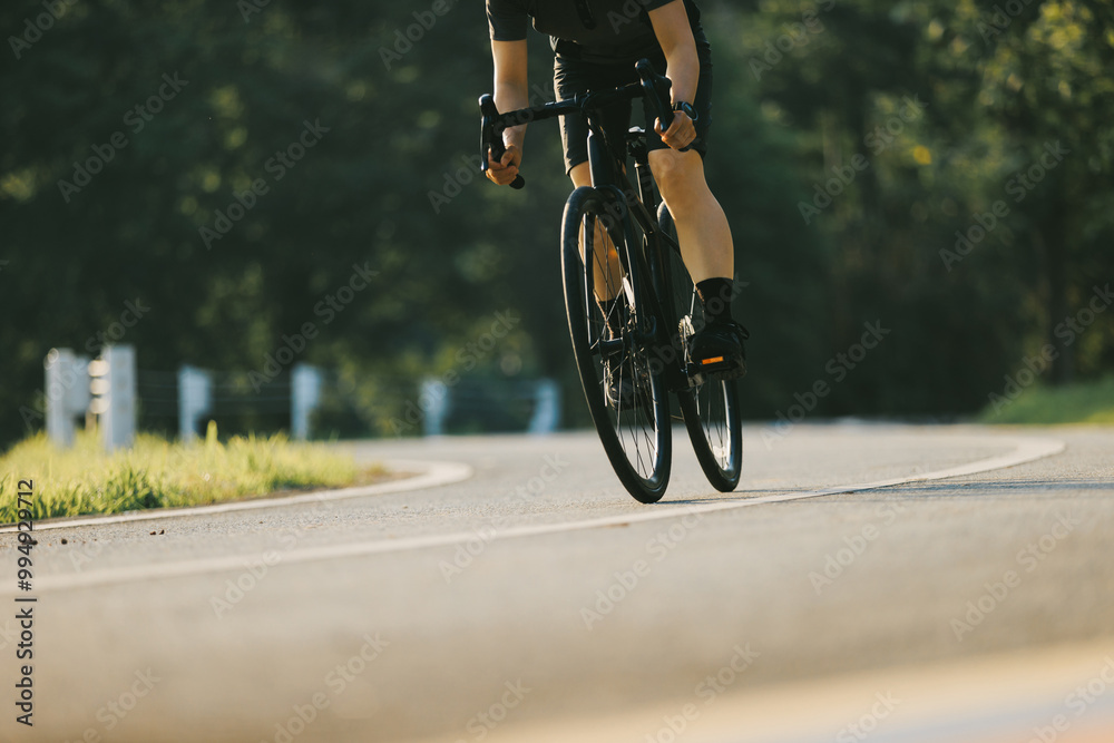 Naklejka premium Woman cycling on summer park trail