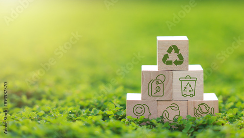 Wooden block with icons for recycling, recycling symbol, bins, plastic bottles and reducing carbon emissions, protect the environment, reducing waste, recycling materials. earth day.