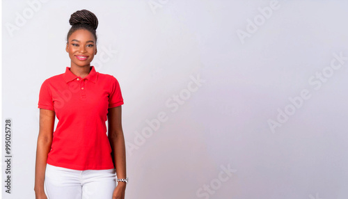 A portrait of a Black woman wearing a red polo shirt and white skinny pants against a background of white walls.