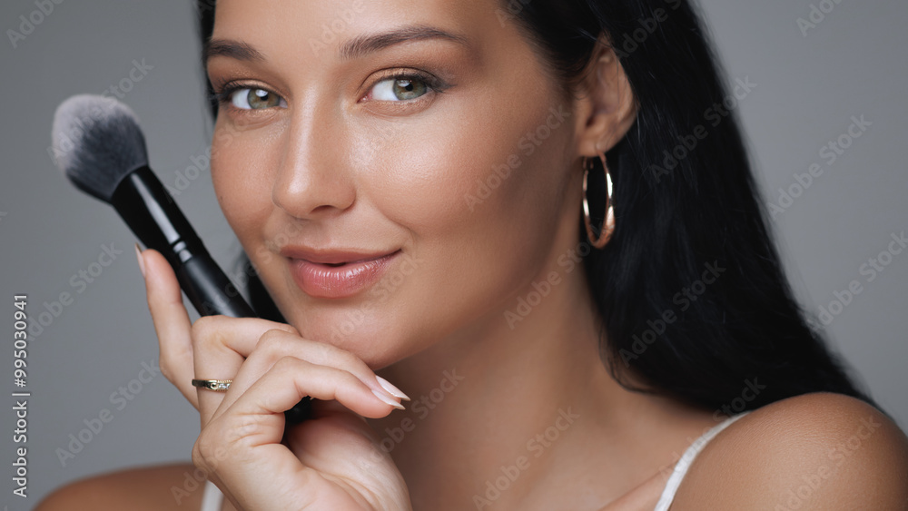 Smiling Woman Holding Makeup Brush Highlighting Flawless Skin Smiling Woman Holding Makeup Brush Highlighting Flawless Skin