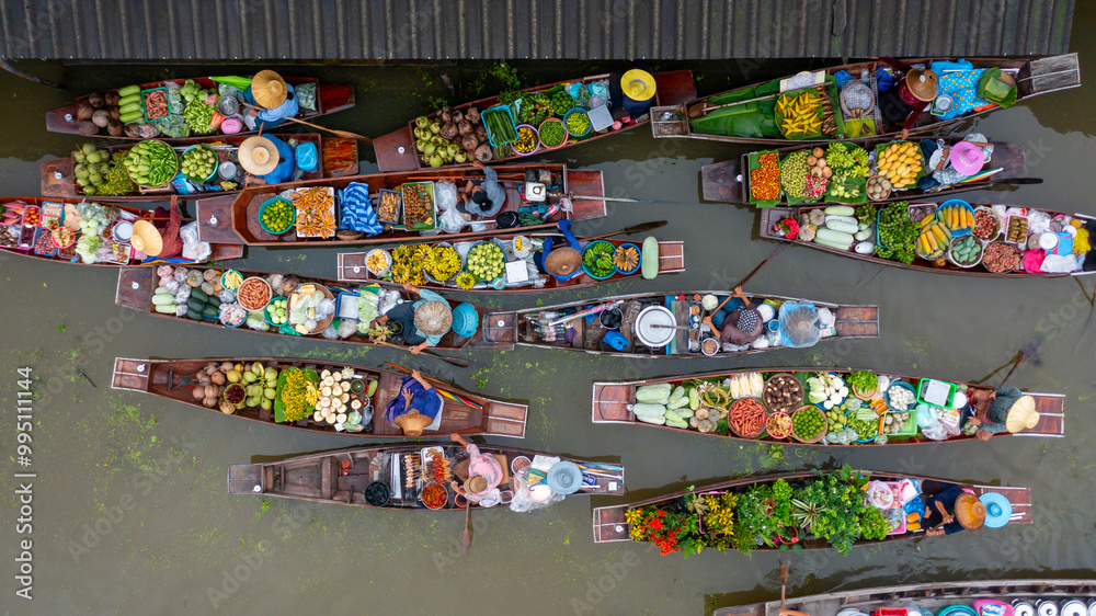 Fototapeta premium Aerial view Damnoen Saduak floating market, Farmer go to sell organic product, fruit, vegetable and Thai cuisine, Tourist visiting by boat, Ratchaburi, Thailand, Famous floating market in Thailand.