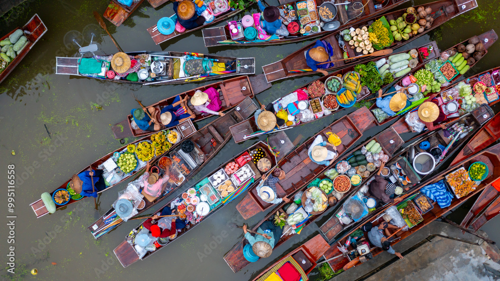 Fototapeta premium Aerial view Damnoen Saduak floating market, Farmer go to sell organic product, fruit, vegetable and Thai cuisine, Tourist visiting by boat, Ratchaburi, Thailand, Famous floating market in Thailand.