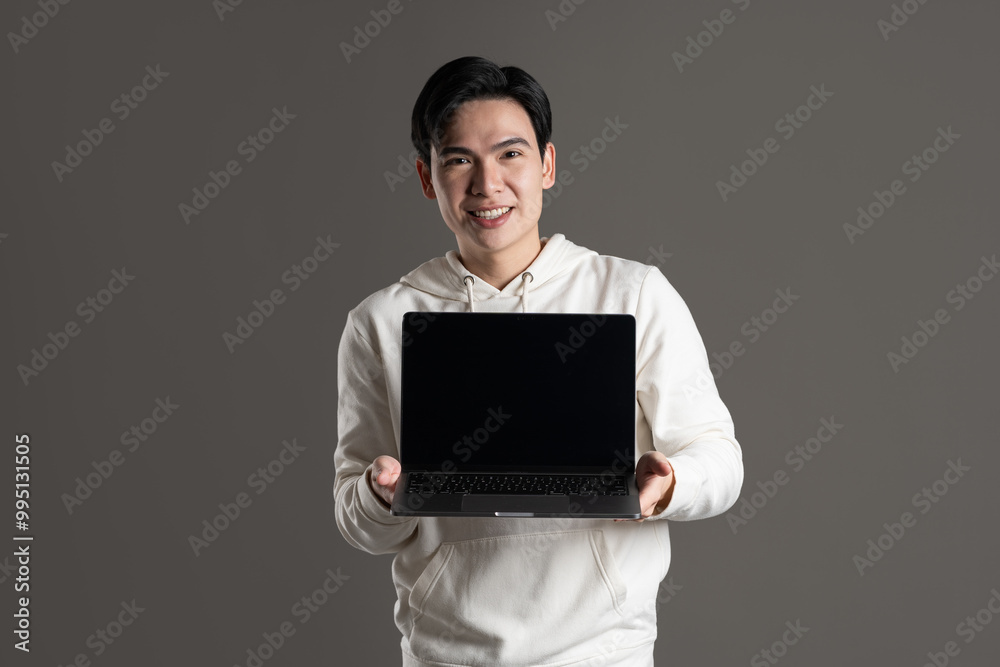 Portrait of Asian man wearing hoodie and posing on gray background. Portrait of Asian man wearing hoodie and posing on gray background.