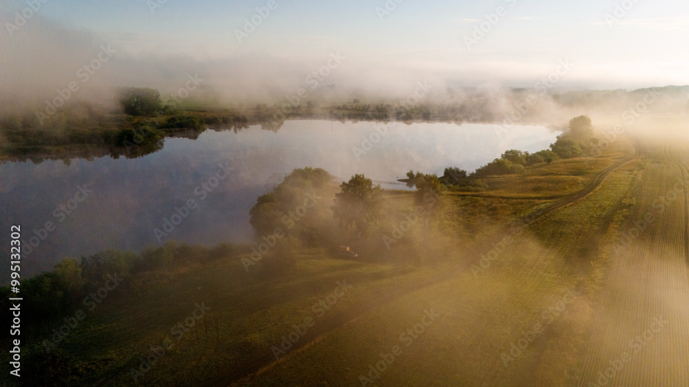 Fog rises from the lake at dawn Fog rises from the lake at dawn