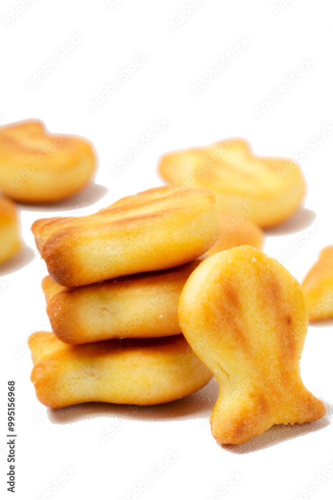A collection of savory, bite-sized biscuits shaped like cute fish silhouettes, perfect as a snack. Photographed against a white background. A collection of savory, bite-sized biscuits shaped like cute fish silhouettes, perfect as a snack. Photographed against a white background.