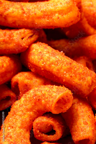A bowl of crispy, deep-fried macaroni snack coated in spicy red seasoning. Crunchy, savory, and perfect for anytime snacking. Photographed on a white background.