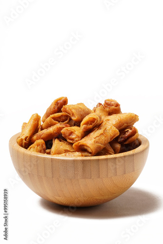 A bowl of Sumpia, Indonesian traditional mini spring rolls filled with shrimp floss. The crunchy outer wrapper is deep-fried to perfection. Photographed on a white background.