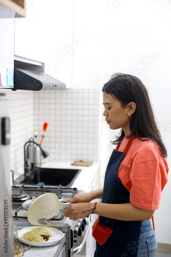 Young Asian Woman Cooking Instant Noodles in The Kitchen